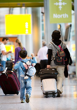 Mother and son walking through airport